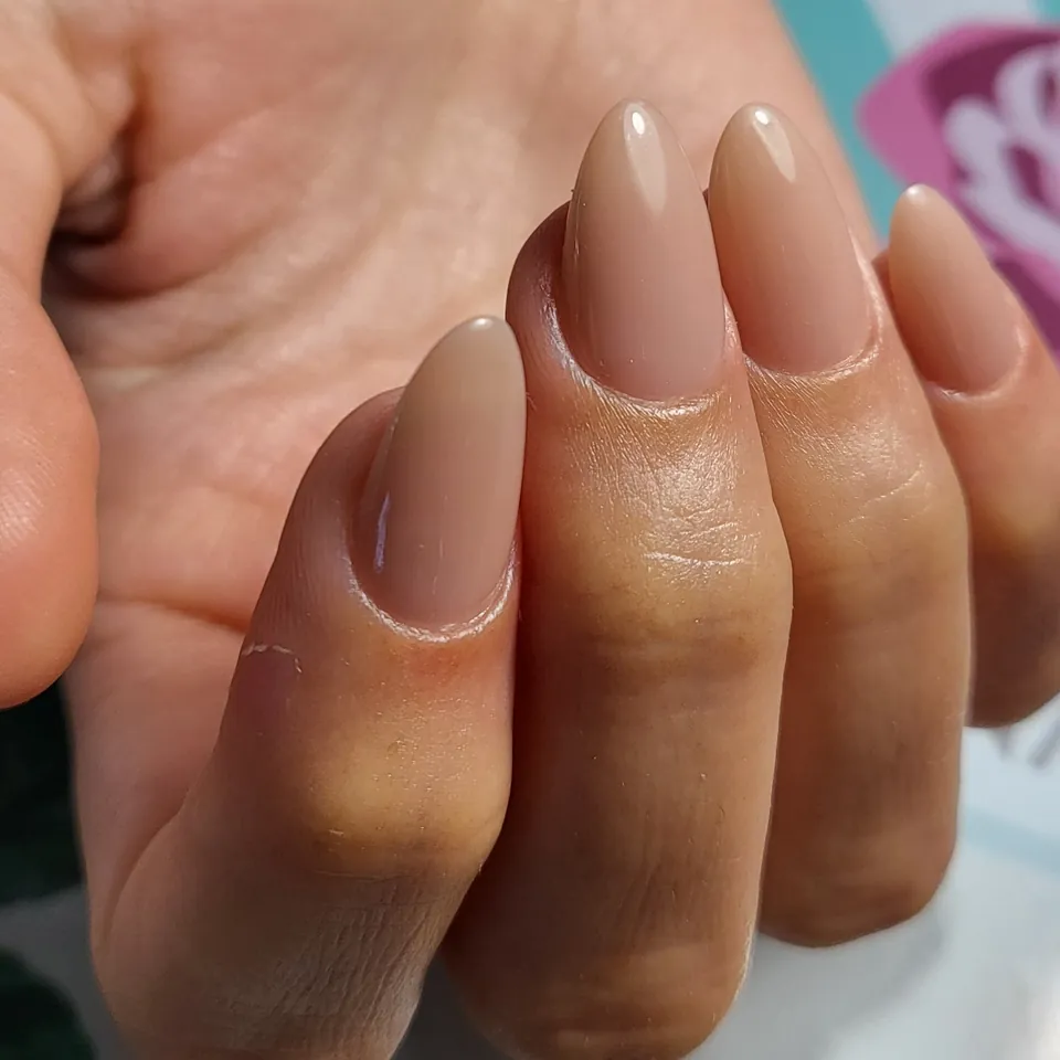 Uñas almendradas largas en nude, con esmaltado parejo y la cutícula prolija.